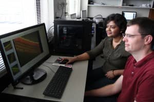 Assistant Professor of Biology Benjamin J. Perrin, PhD (R) and graduate student Pallabi Roy, MS (L) look at an image of auditory sensory hair cells in the Perrin lab in the School of Science at IUPUI.