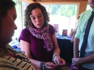 Oticon Manager of Clinical Studies Randi Pogash, AuD, who has also been instrumental in organizing the Summer Camps, explains the art of earmolds and impression-taking to a student.