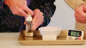 Figure 3. The button on the top of the dye bottle is depressed, allowing the dye to flow into the mixture below.