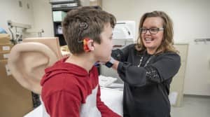Rene Gifford, PhD, works with patient Davy Hillis to program his cochlear implant. (photo by John Russell)