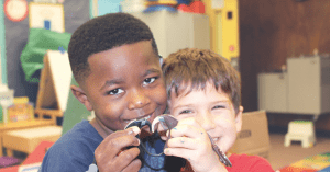 Clients hold a hearing aid at The Center for Hearing and Speech on West Dallas. (Photo courtesy of The Center for Hearing and Speech)