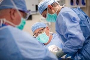 Craig Buchman, MD (center), of Washington University School of Medicine in St. Louis, works with resident Paul Zolkind, MD (right) during a skull surgery that involves loud drilling. Exposure to this noise can cause hearing loss in patients in the days after such surgery. Buchman and his colleagues are evaluating whether a drug used to treat epilepsy can prevent noise-induced hearing loss in such patients when they take the drug several hours before exposure to loud noise.