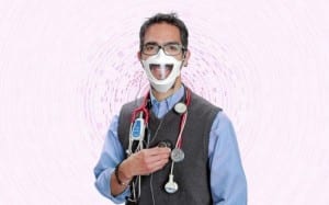 Dr Sam Atcherson wears medical equipment, a transparent face mask and amplified stethoscope he is researching that is designed to help deaf and hard-of-hearing patients and doctors better communicate.